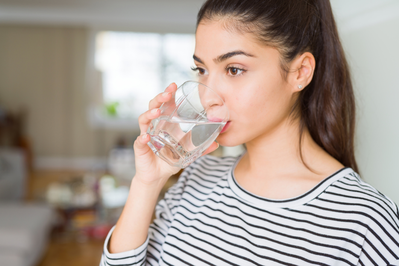 young woman drinking a glass of water