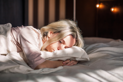 menopausal woman lying in bed struggling to sleep