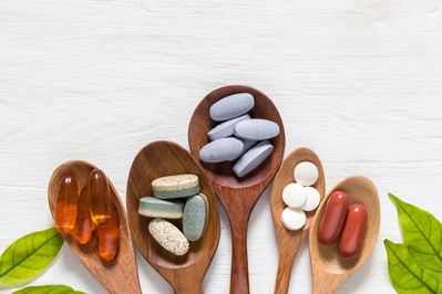 wooden spoons with various vitamins and supplements