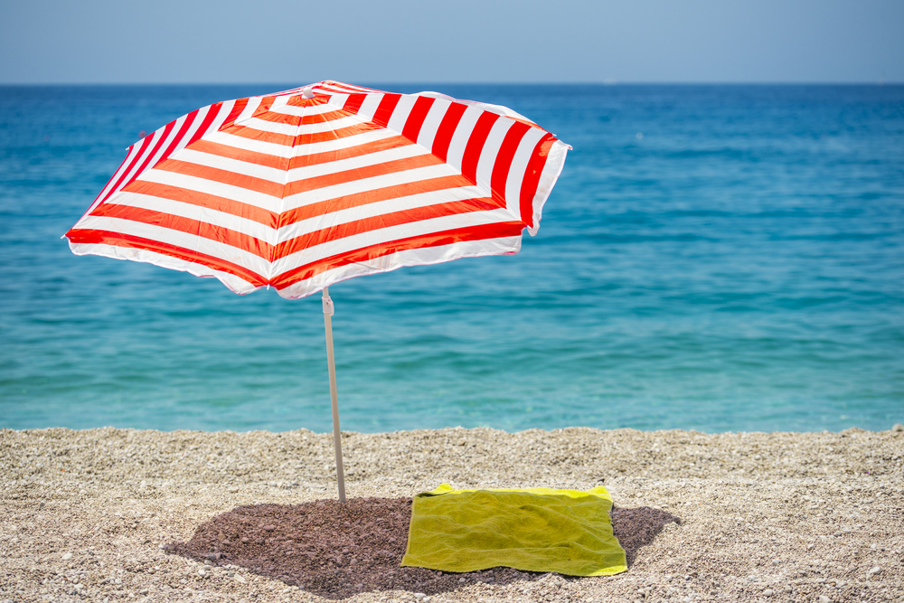 towel spread out under umbrella on a beach