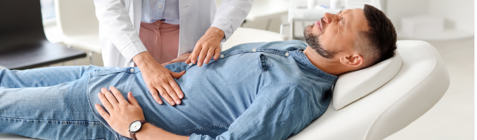 man lying on table having his stomach examined