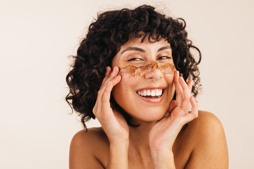 woman exfoliating face with coffee scrub