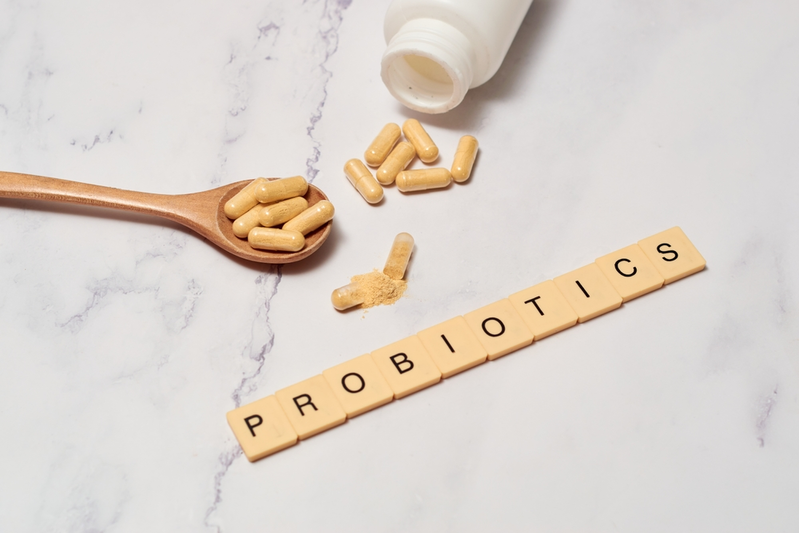 letter tiles spelling PROBIOTICS next to probiotic supplements