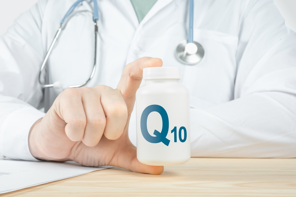 doctor holding pill bottle labeled Q10