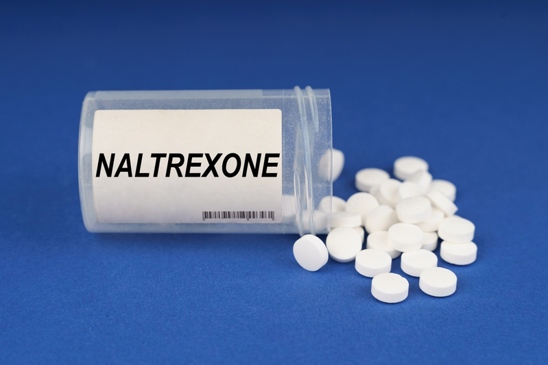 white pills spilling from bottle labeled NALTREXONE