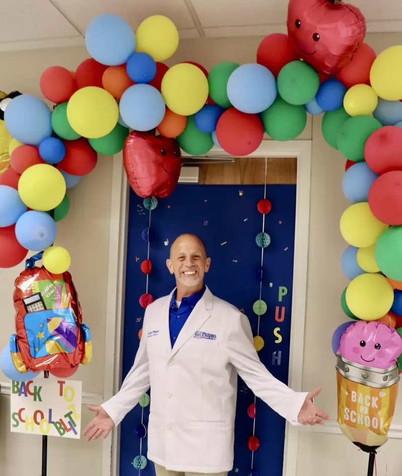 Jay standing under balloon arch